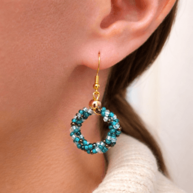 Oorhangers met turquoise kralen in oor